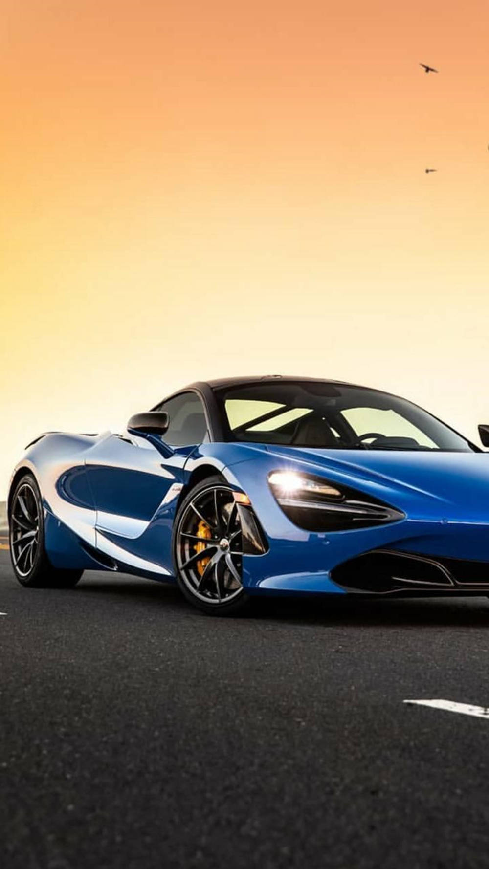 नीला मैकलारेन 720S सूर्यास्त के नीचे फोन वॉलपेपर