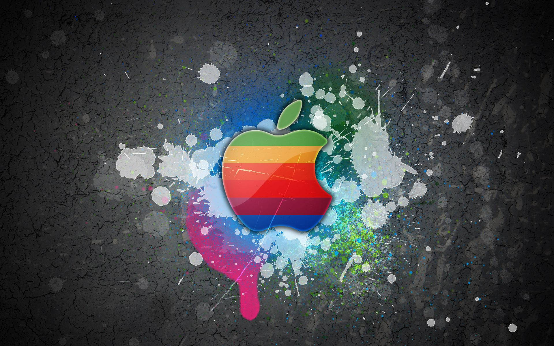 पेंट के छींटे वाली ग्रे दीवार पर Apple Macbook लोगो का कूल रंगीन वॉलपेपर — कूल जीआईएफ वॉलपेपर