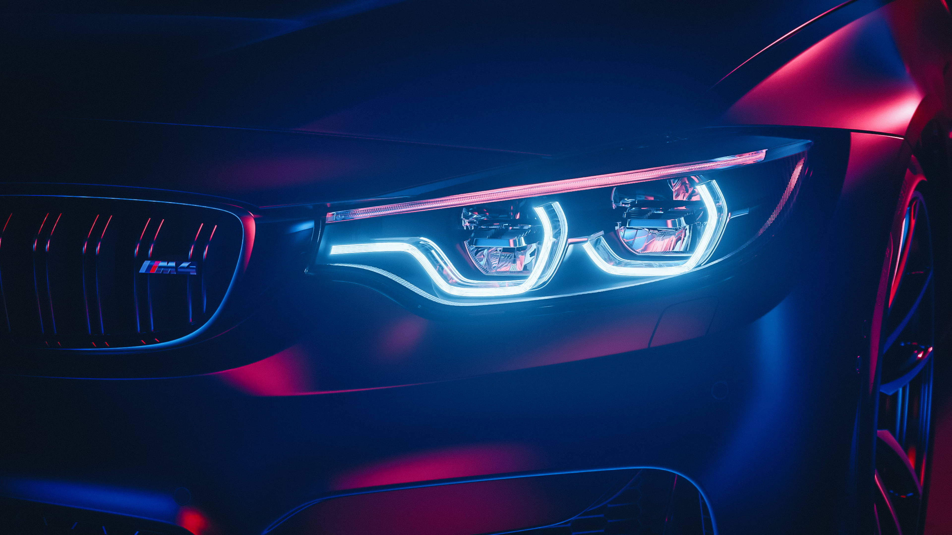 BMW M4 की चमकदार हेडलाइट्स का क्लोज़-अप वॉलपेपर