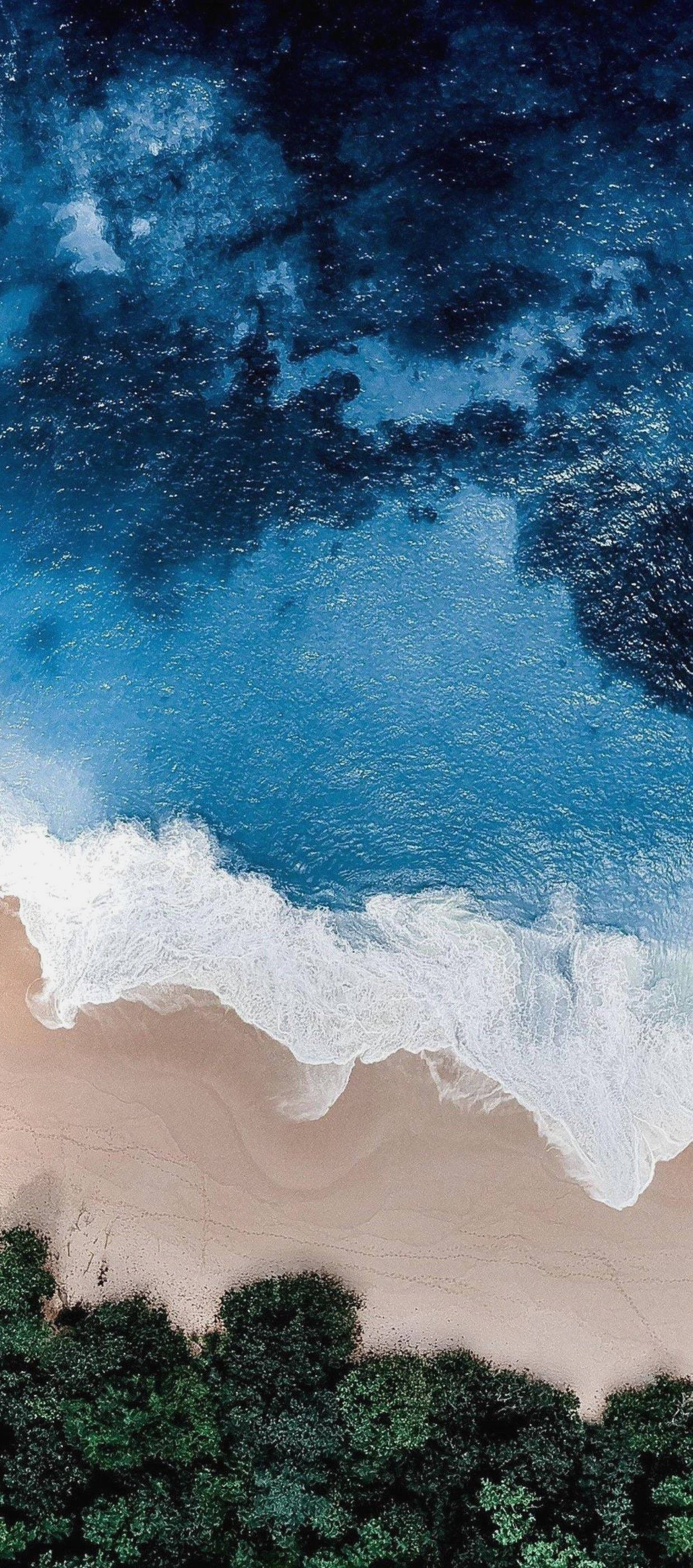 iPhone 11 समुद्र तट के ऊपर उड़ता हुआ वॉलपेपर