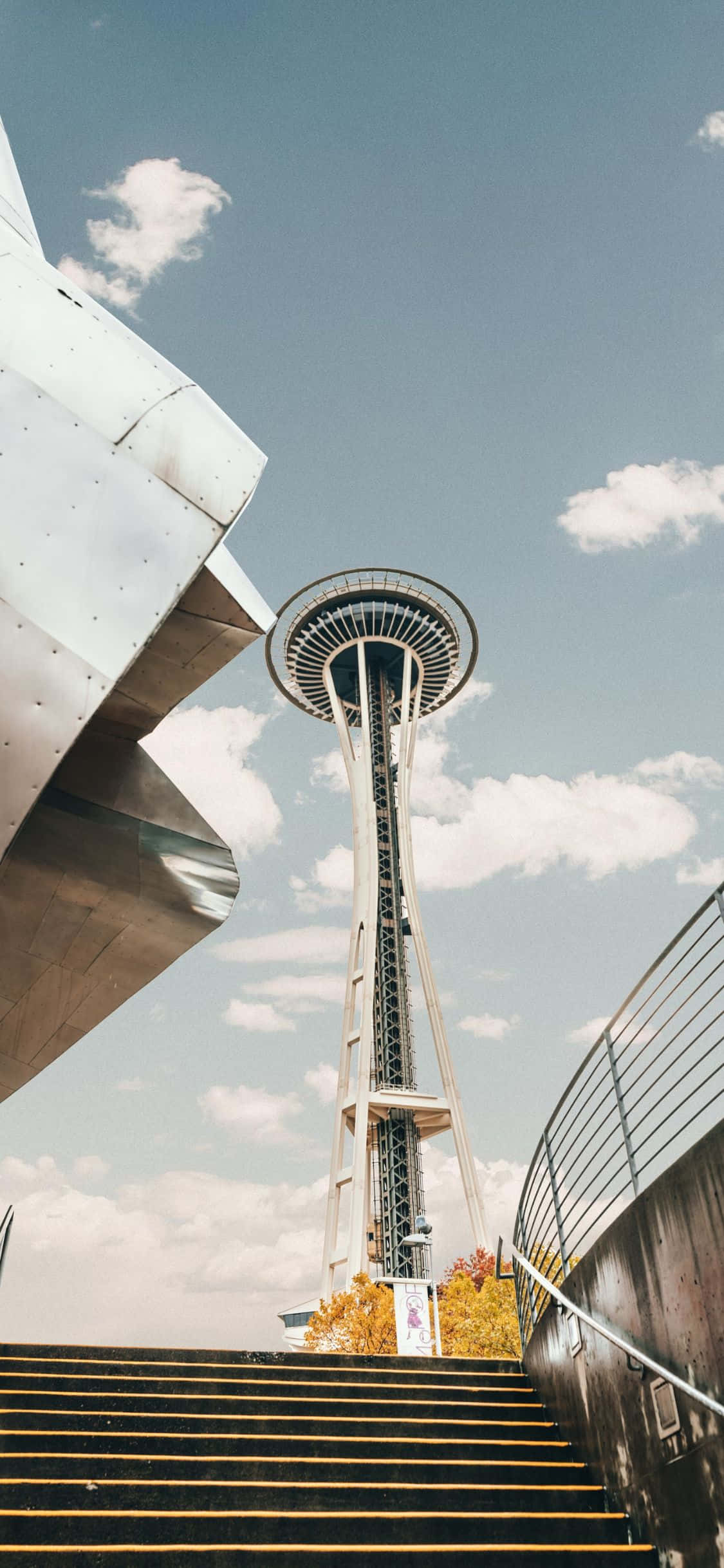 एक आदमी इमारत की सीढ़ियों से नीचे उतर रहा है वॉलपेपर