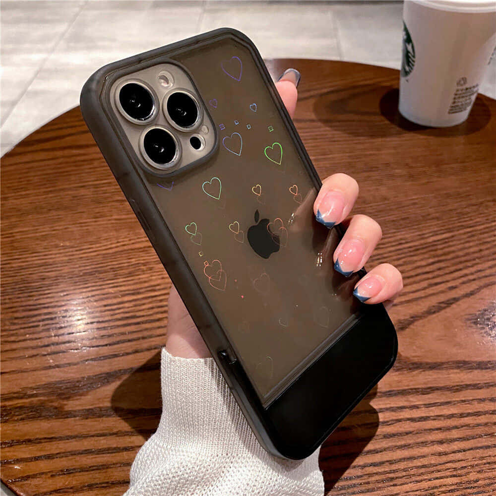 एक महिला के हाथ में दिलों वाला iPhone 11 केस वॉलपेपर