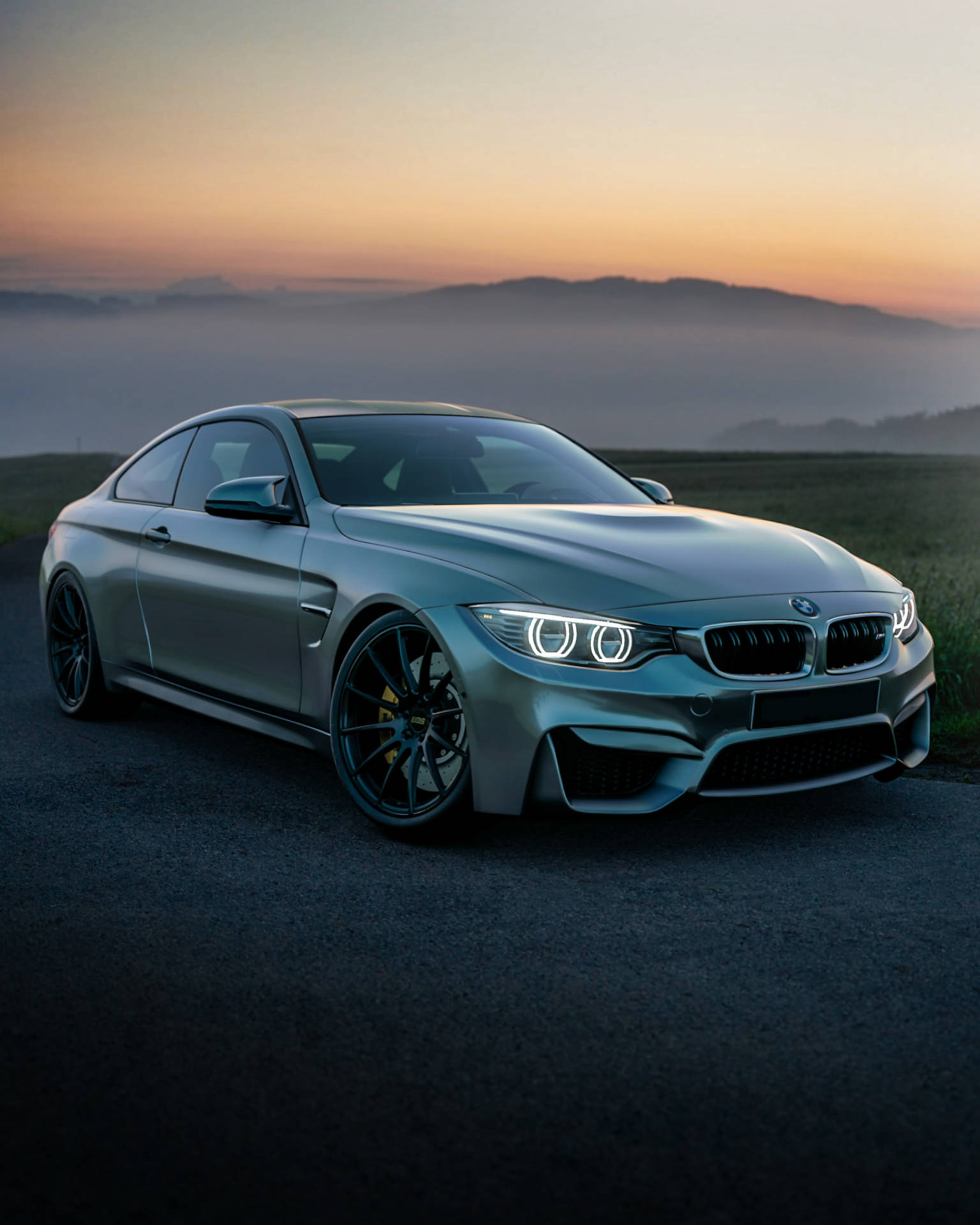 सूर्योदय के समय पहाड़ पर ग्रे BMW F83 M4 कार वॉलपेपर — Bmw वॉलपेपर