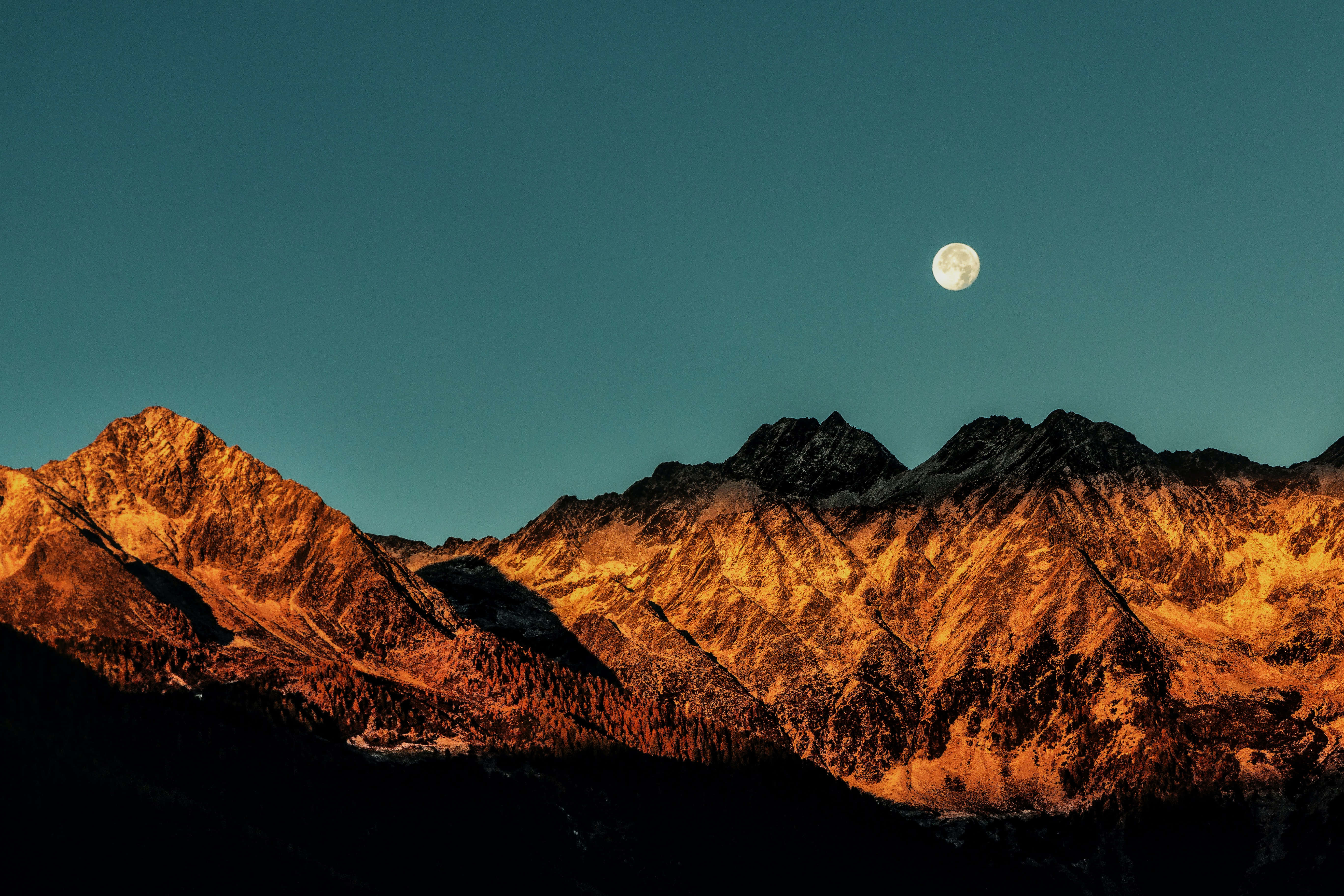 पहाड़ पर चाँद के साथ सूर्योदय की रोशनी का चित्र वॉलपेपर