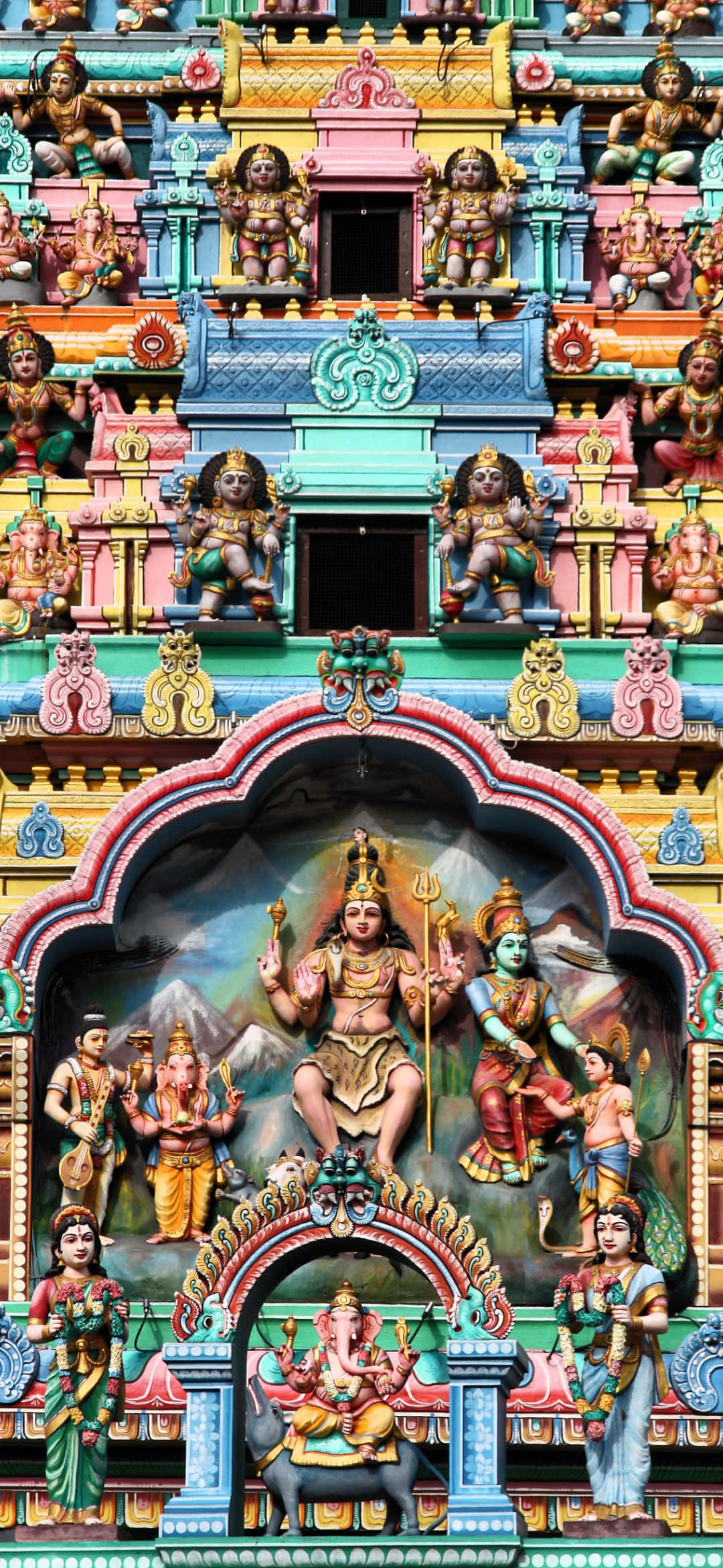 पहाड़ी आसमान के सामने एक पुरानी औद्योगिक इमारत जिसमें एक ट्रैक्टर है वॉलपेपर