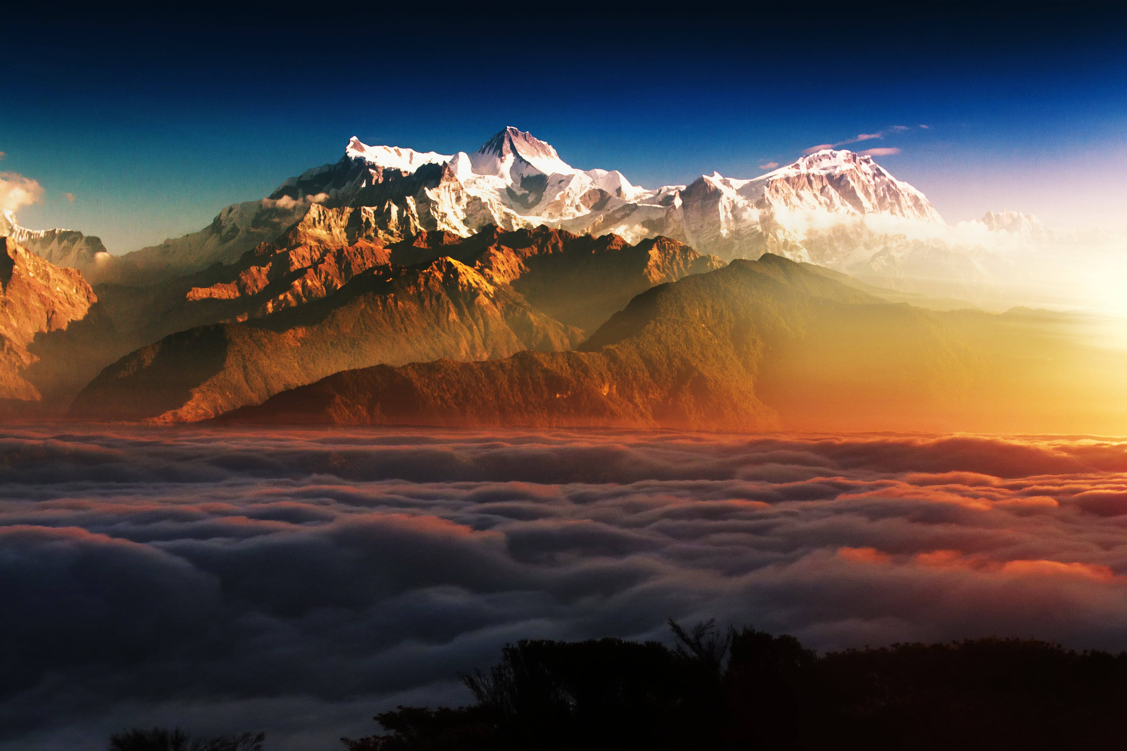 बादलों से घिरी पर्वत चोटियों का दृश्य वॉलपेपर