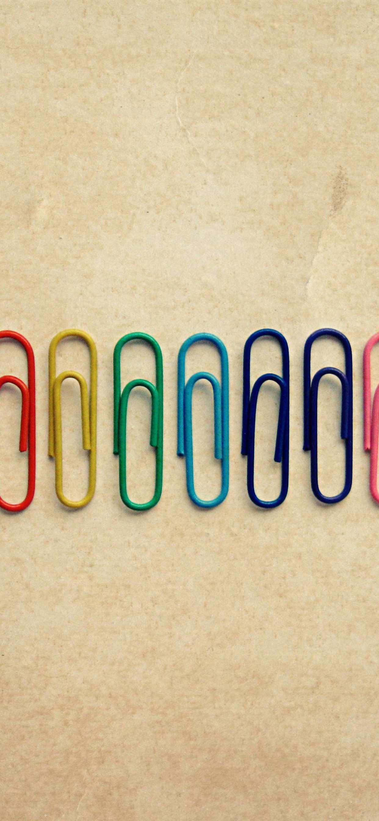 रंगीन पेपर क्लिप्स की एक पंक्ति वॉलपेपर