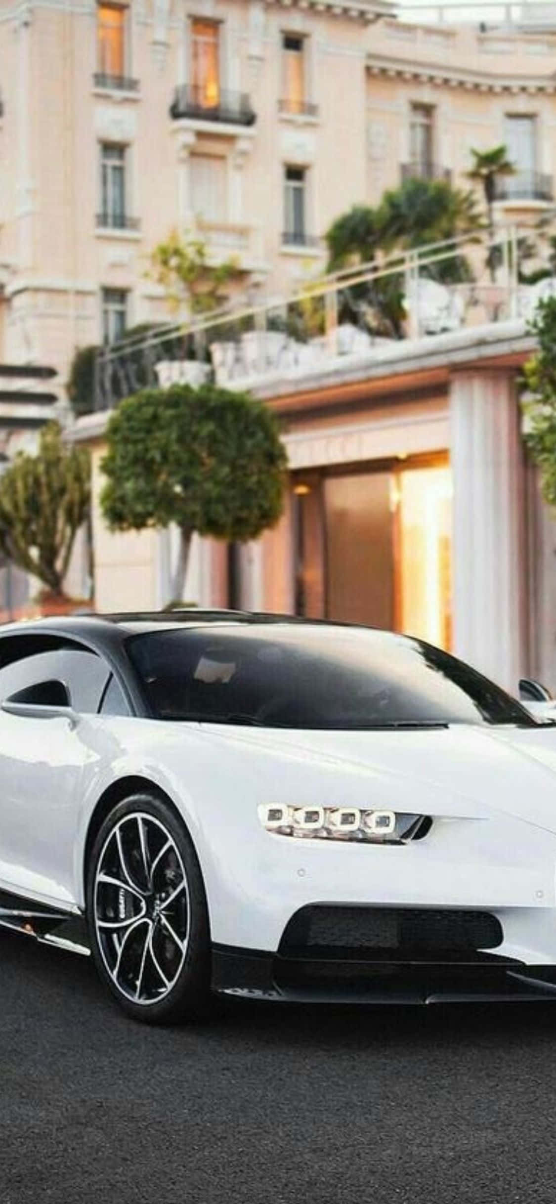 सफेद Bugatti Chiron एक इमारत के सामने खड़ी है वॉलपेपर