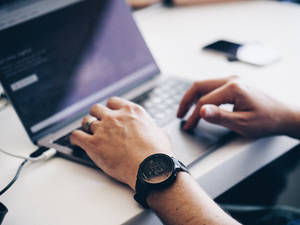 कीबोर्ड पर टाइप करता आदमी — MacBook Pro वॉलपेपर