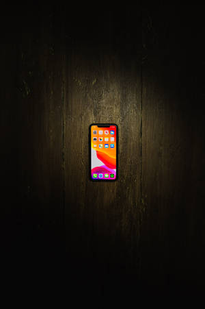 लकड़ी के फर्श पर iPhone xs max वॉलपेपर