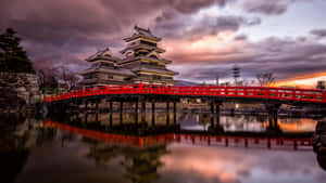 सूर्यास्त के समय बादलों के बीच मात्सुमोटो कैसल — Japan GIF वॉलपेपर